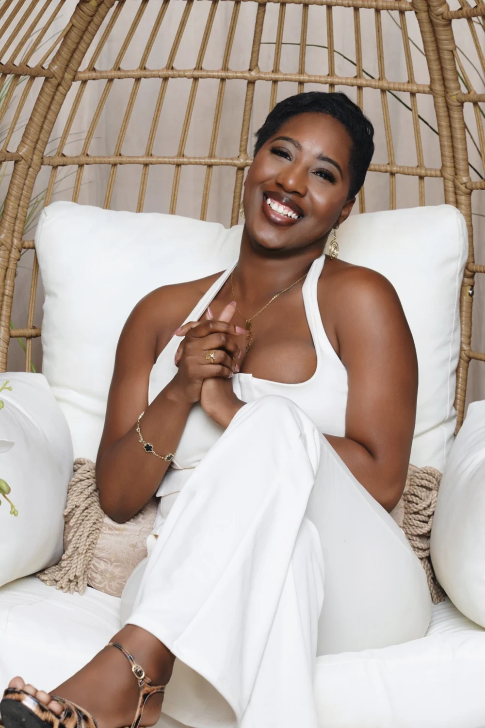 Rickaya seated in a cream outfit